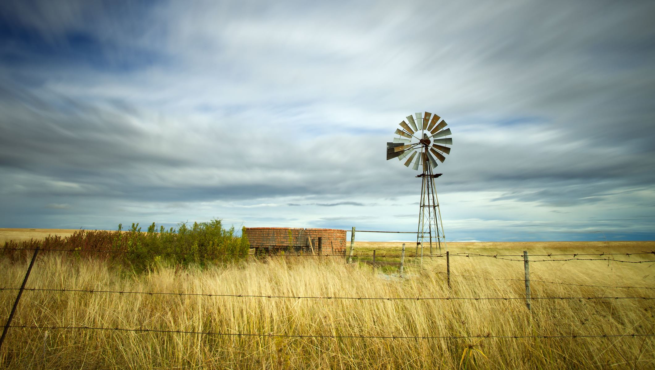windmill in field with cloudy sky
